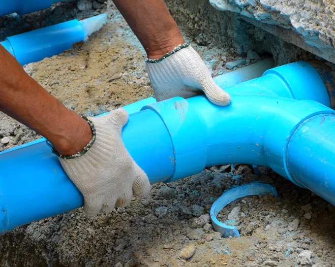 plumber wearing gloves changing sewer pipes